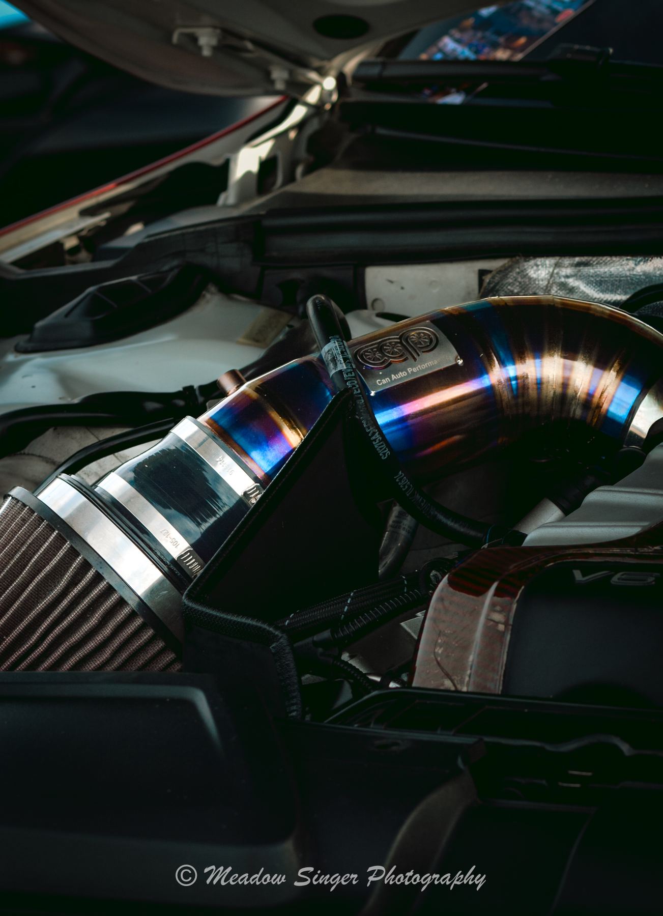A blue intake pipe in a tuned engine bay