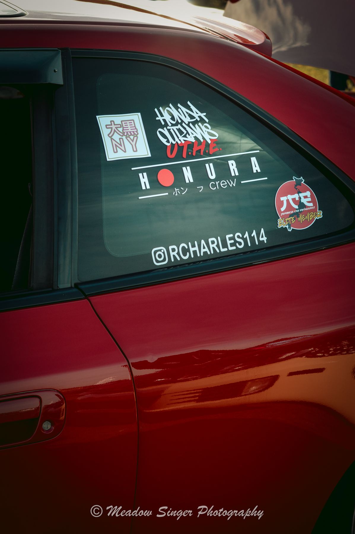 Club stickers on the window of a red car