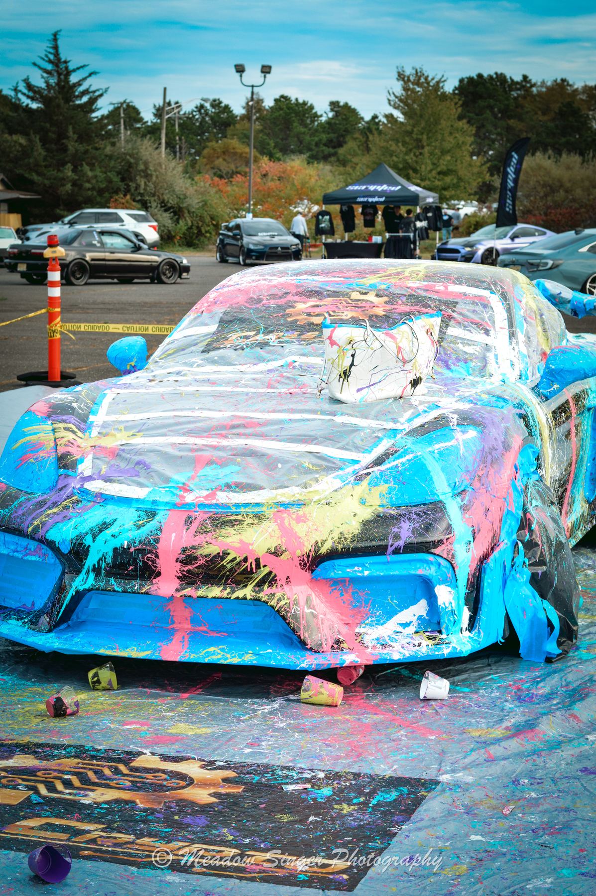 A car covered in splashed paint at a show